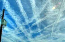 chemtrails criss-crossing over  blue sky